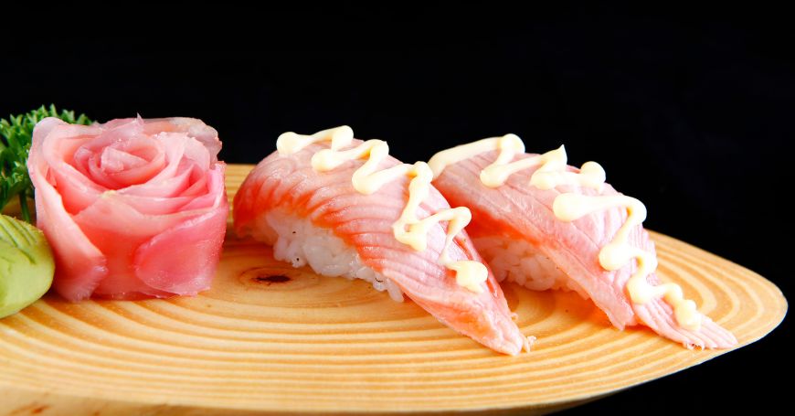 due pezzi di nigiri di tonno tataki con salsa, accompagnati da un sashimi di tonno rosso